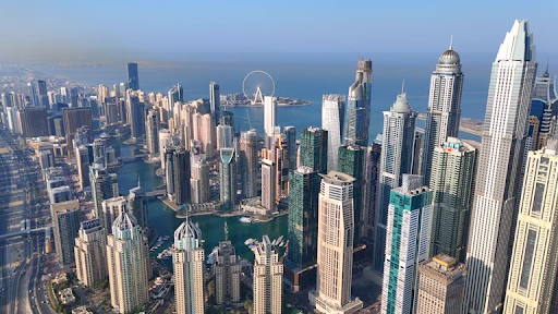 Aerial view of Dubai skyline, showcasing modern skyscrapers and the coastline.